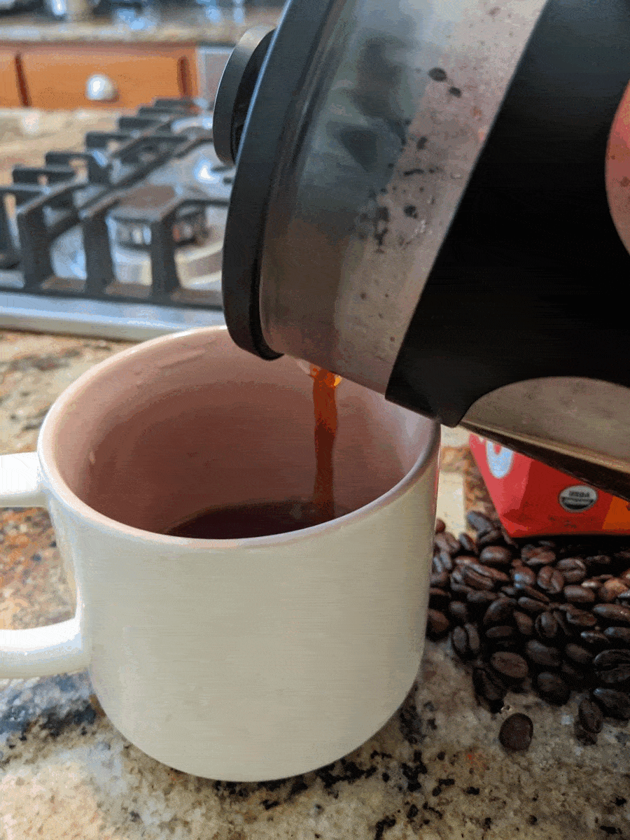 pouring brewed Peace Coffee into a cup from a teapot