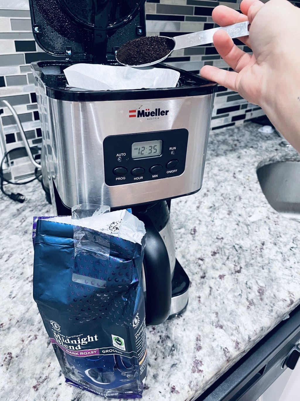 pouring coffee into the coffee maker 