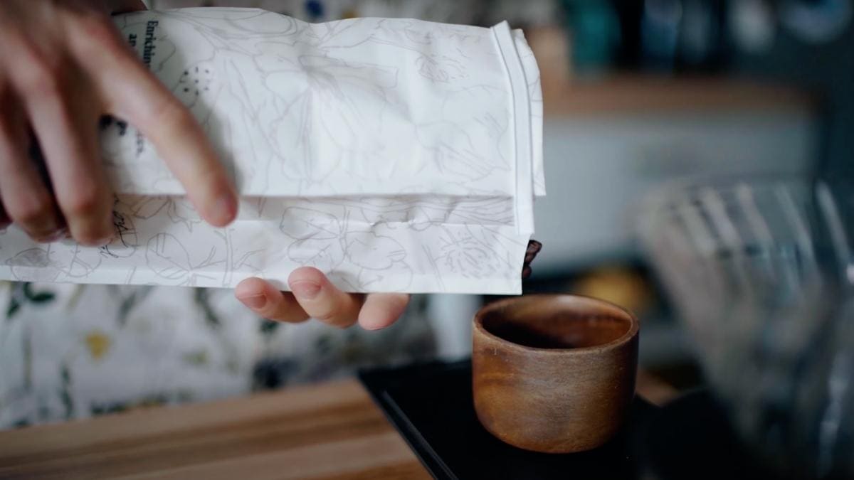 pouring MistoBox coffee into a wooden cup